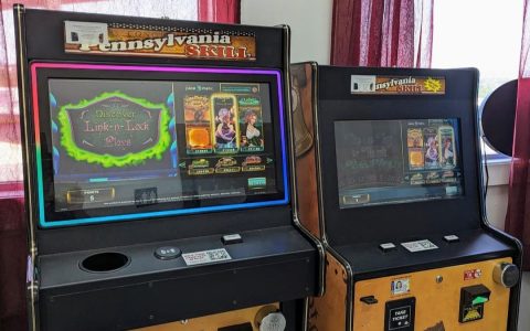 Two Pennsylvania Skill game machines with lit screens standing side by side inside a business