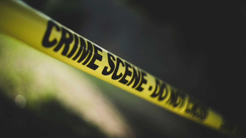 Current image: Yellow police tape reading CRIME SCENE DO NOT CROSS stretched across a dark background