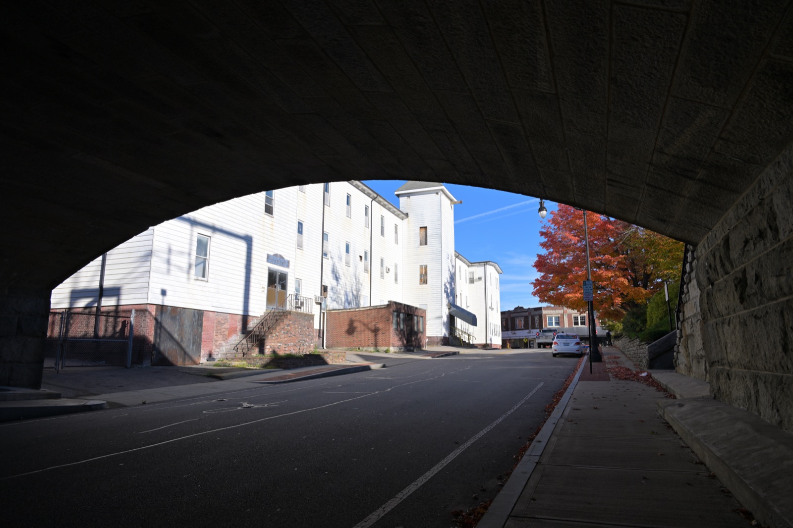 Mill Street in Attleboro, Massachusetts, seen from under a stone railroad bridge