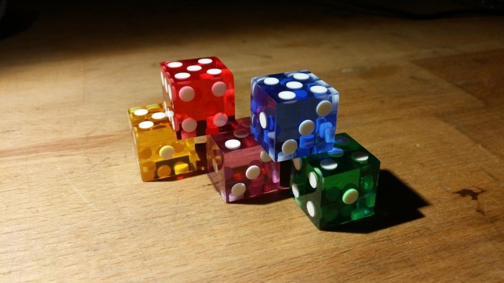 Five translucent casino dice on a wooden table