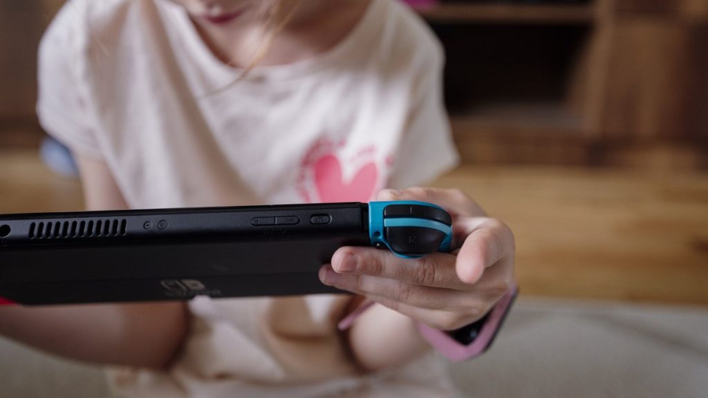 A child holds a handheld game console at home