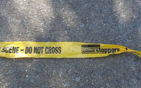 Yellow crime scene tape on pavement