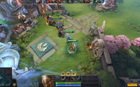 Dota 2 gameplay seen from above, with heroes fighting on a grassy lane beside pink blossom trees