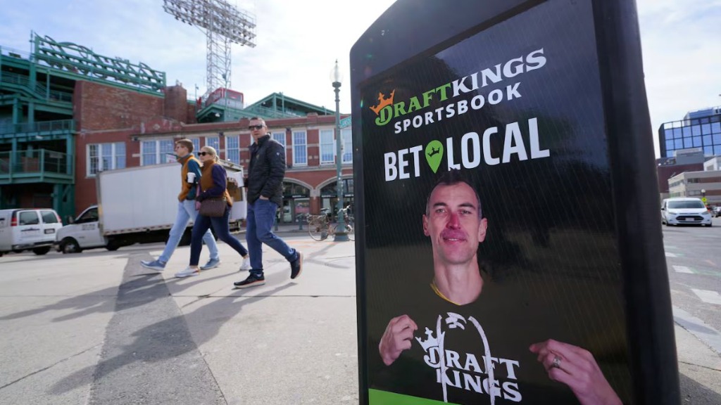 DraftKings Sportsbook advertisement kiosk on a sidewalk near Fenway Park in Boston