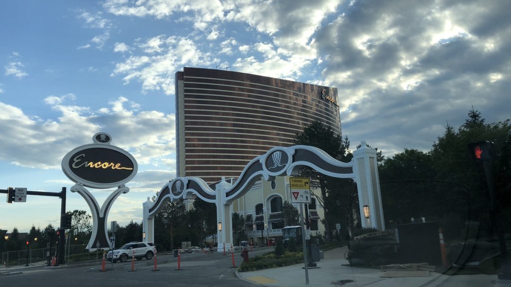 The arched vehicle entrance and sign at Encore Boston Harbor with the hotel tower behind