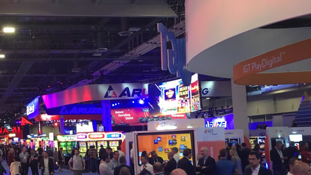 Exhibitor booths and slot machines on the Global Gaming Expo floor, including an IGT PlayDigital sign