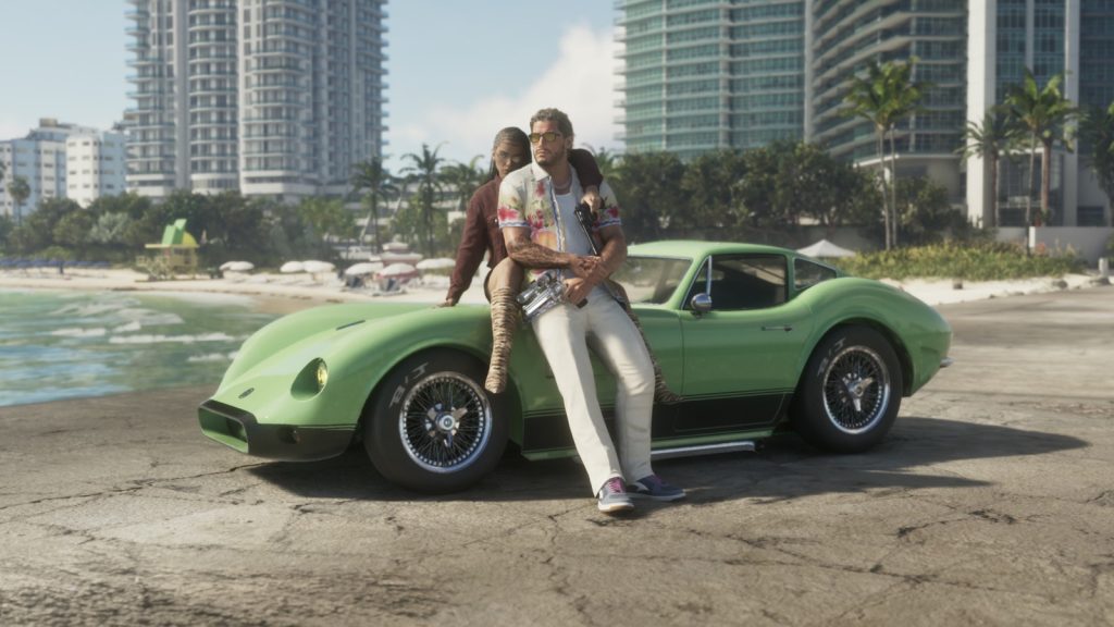 Jason and Lucia sitting on a green sports car parked on a beach in front of high-rise buildings