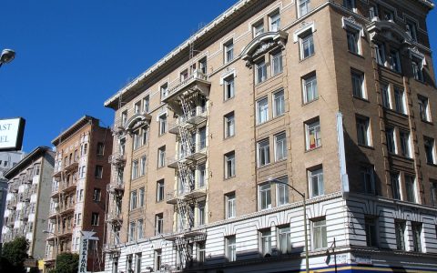 Brick apartment and hotel buildings with fire escapes on Jones Street in the Tenderloin, San Francisco