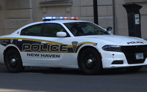 A white New Haven Police Department Dodge Charger cruiser parked on a city street