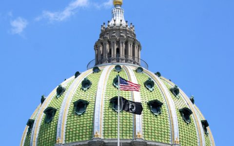 The green-tiled dome of the Pennsylvania State Capitol in Harrisburg under a blue sky