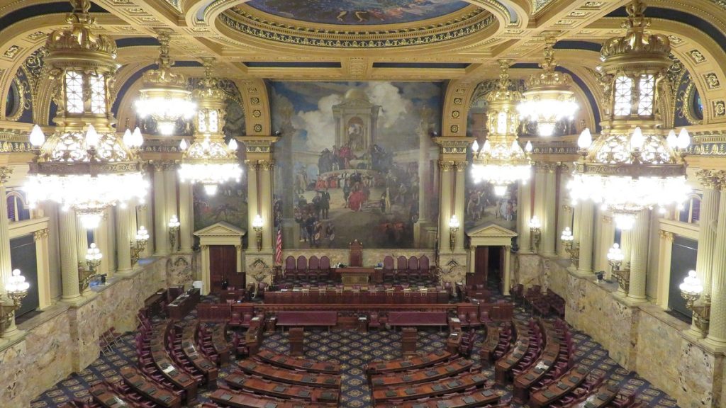 The ornate Pennsylvania House of Representatives chamber with rows of desks