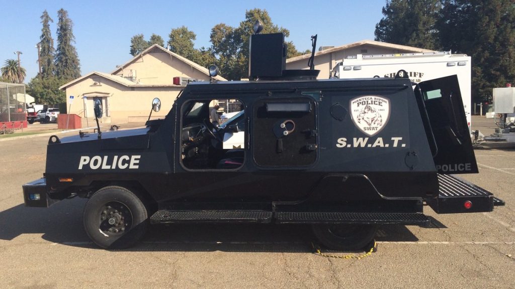 A black police SWAT armored vehicle in a parking lot