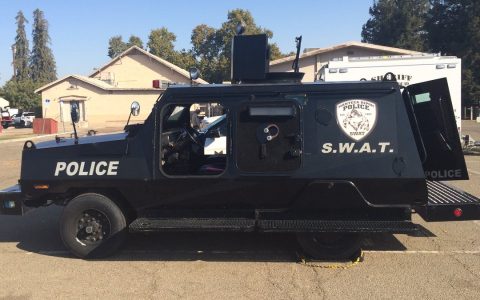 A black police SWAT armored vehicle in a parking lot