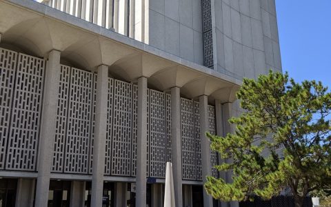 The tall concrete San Mateo County Hall of Justice building in Redwood City, California, with a plaza in front