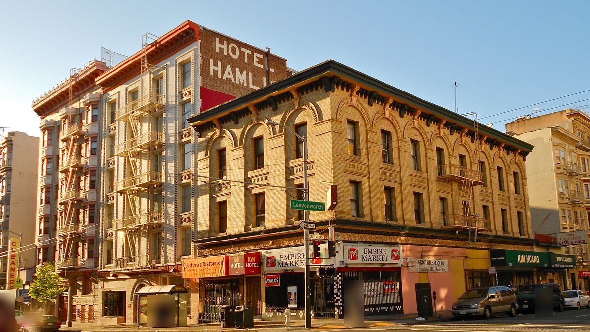 Brick hotel and apartment buildings above corner shops at Leavenworth Street in the Uptown Tenderloin, San Francisco