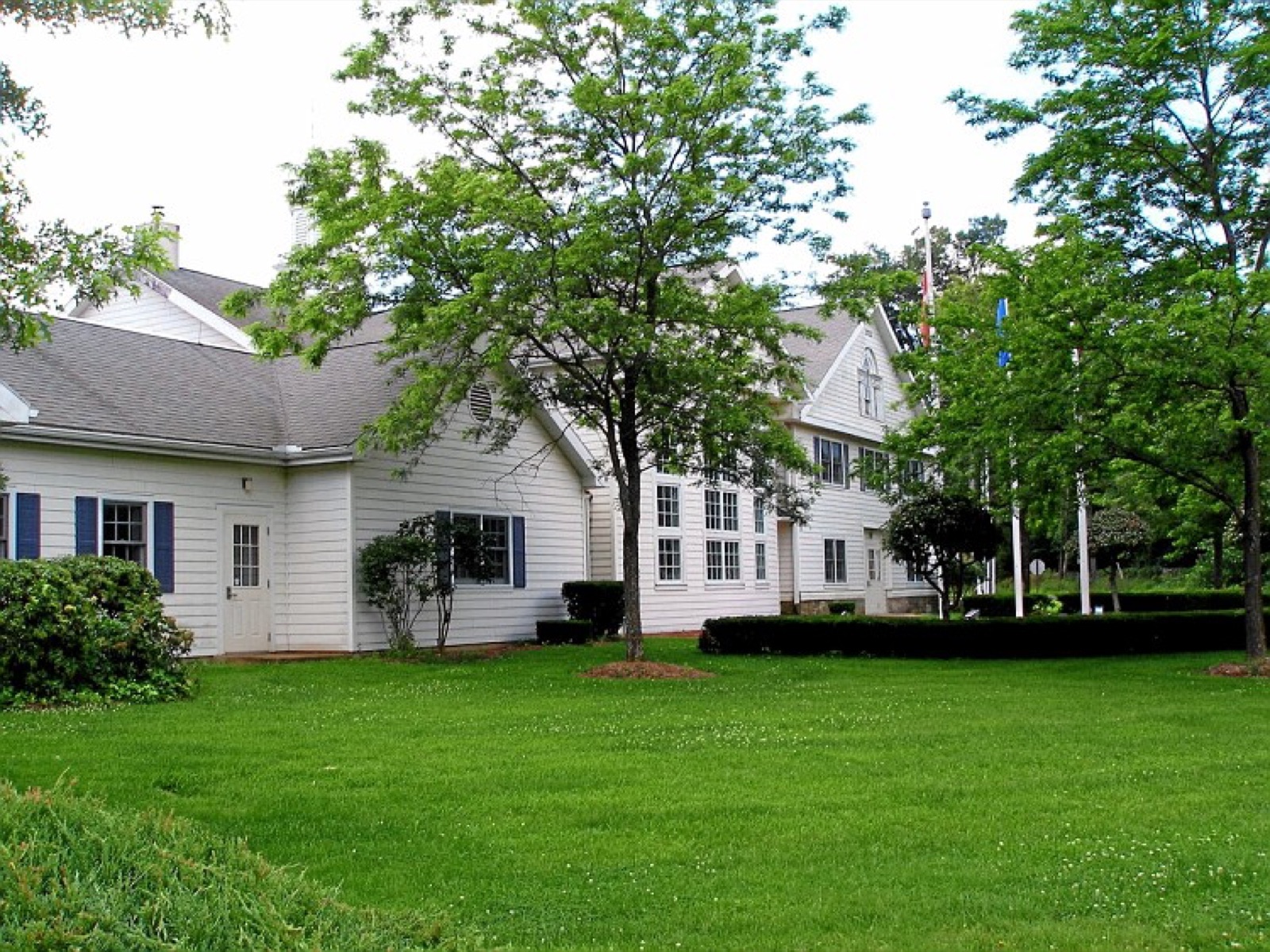 The Town Hall in Wolcott, Connecticut, a white clapboard building behind a green lawn